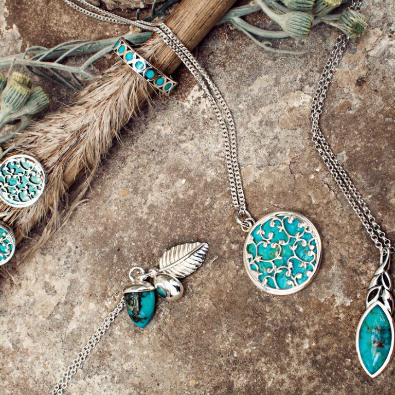 Turquoise & Silver Jewellery Laid on Concrete With Wheat