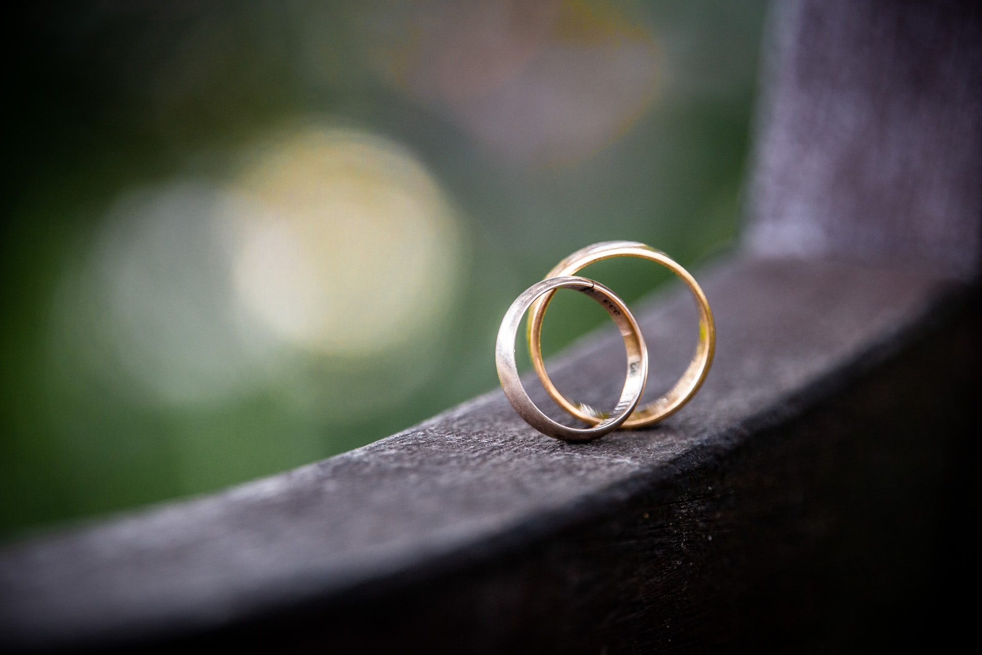 Two gold wedding rings balanced on window ledge