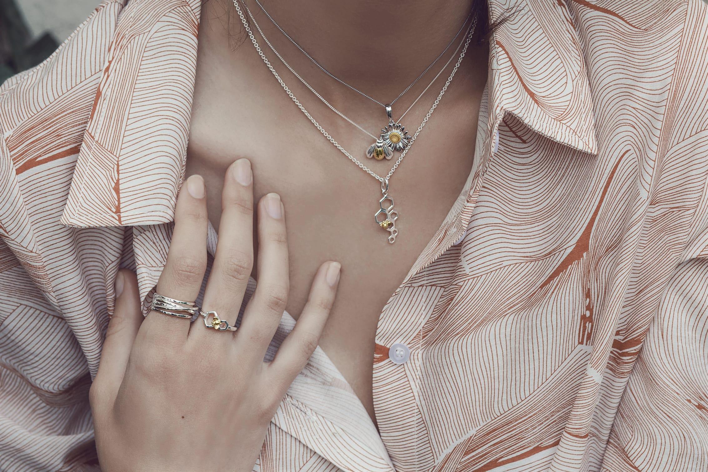 World Bee Day 2021 Model wears jewellery from Joshua James Serenity collection, including bee and honeycomb necklaces and ring.