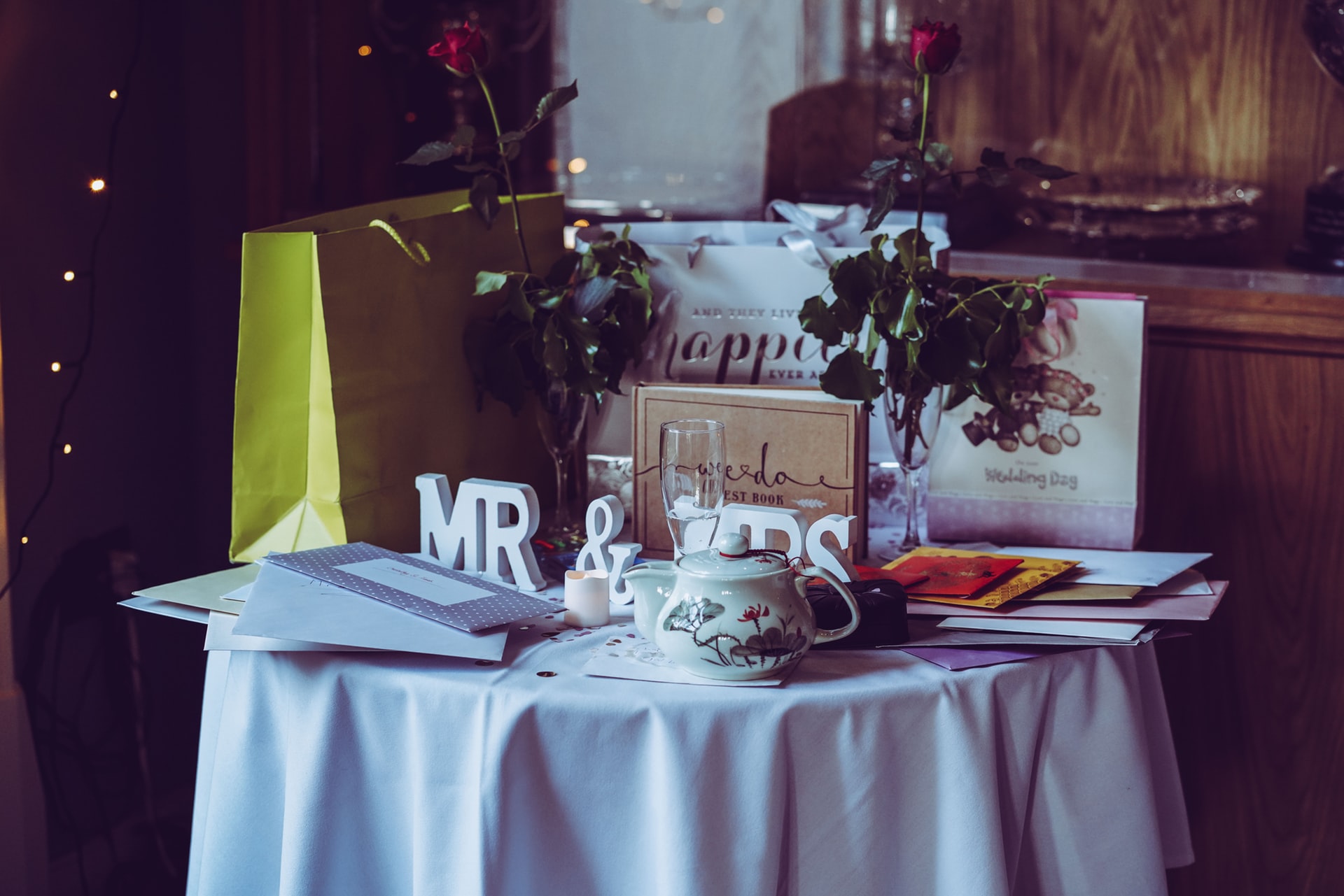 Wedding gifts with two red roses and mr. & mrs. free-standing letters on top of table