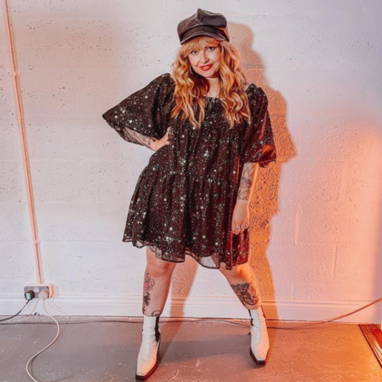 Influencer In Star Print Dress, Leather Baker Hat & White Boots