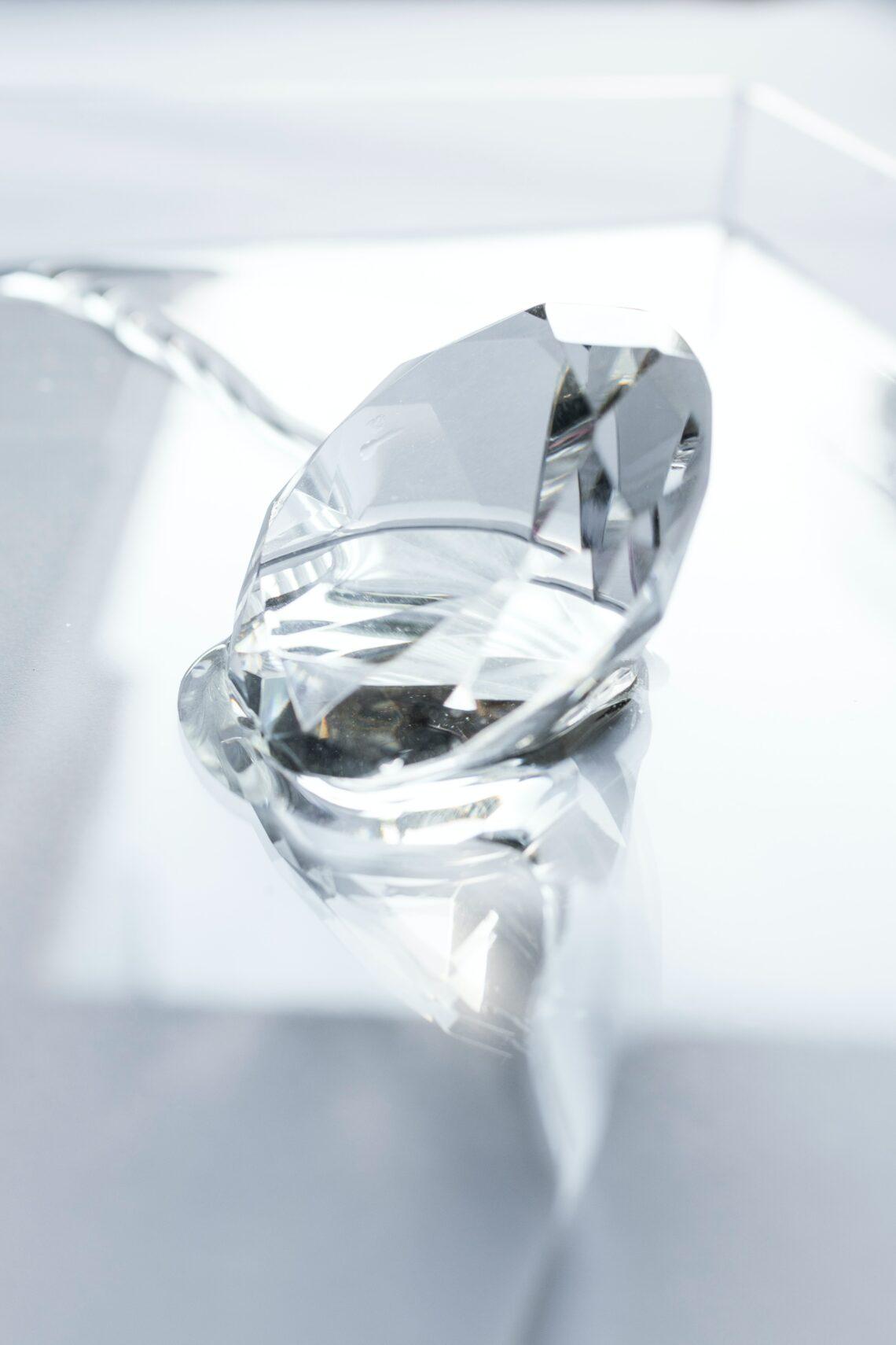 Image shows a diamond on a reflective background.