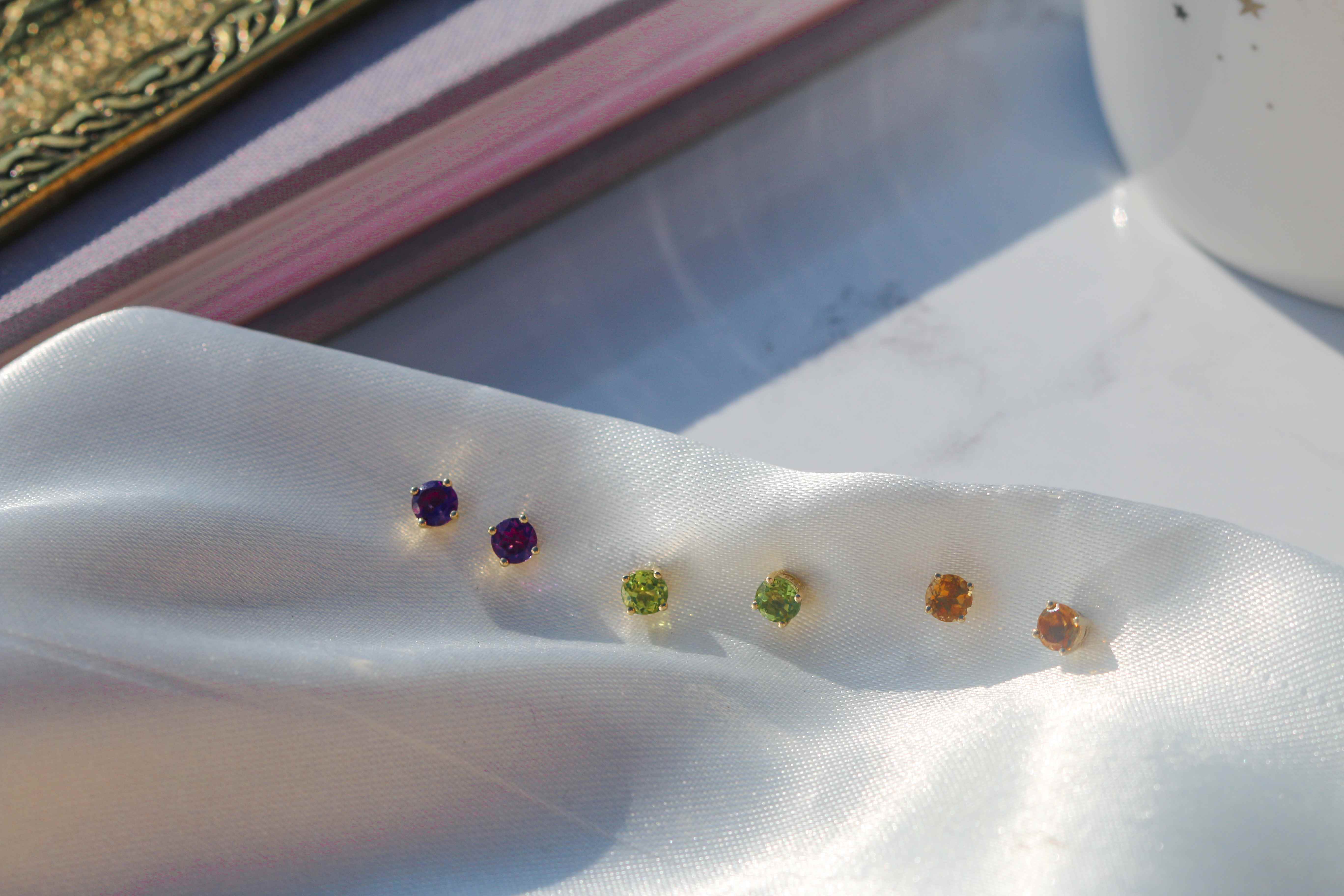 Image shows a selection of gold birthstone earrings